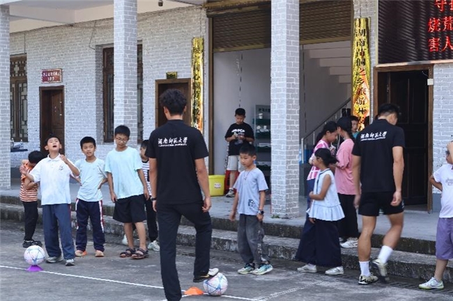 体院“潇湘武韵”实践团在佘家村开展足球趣味传球课