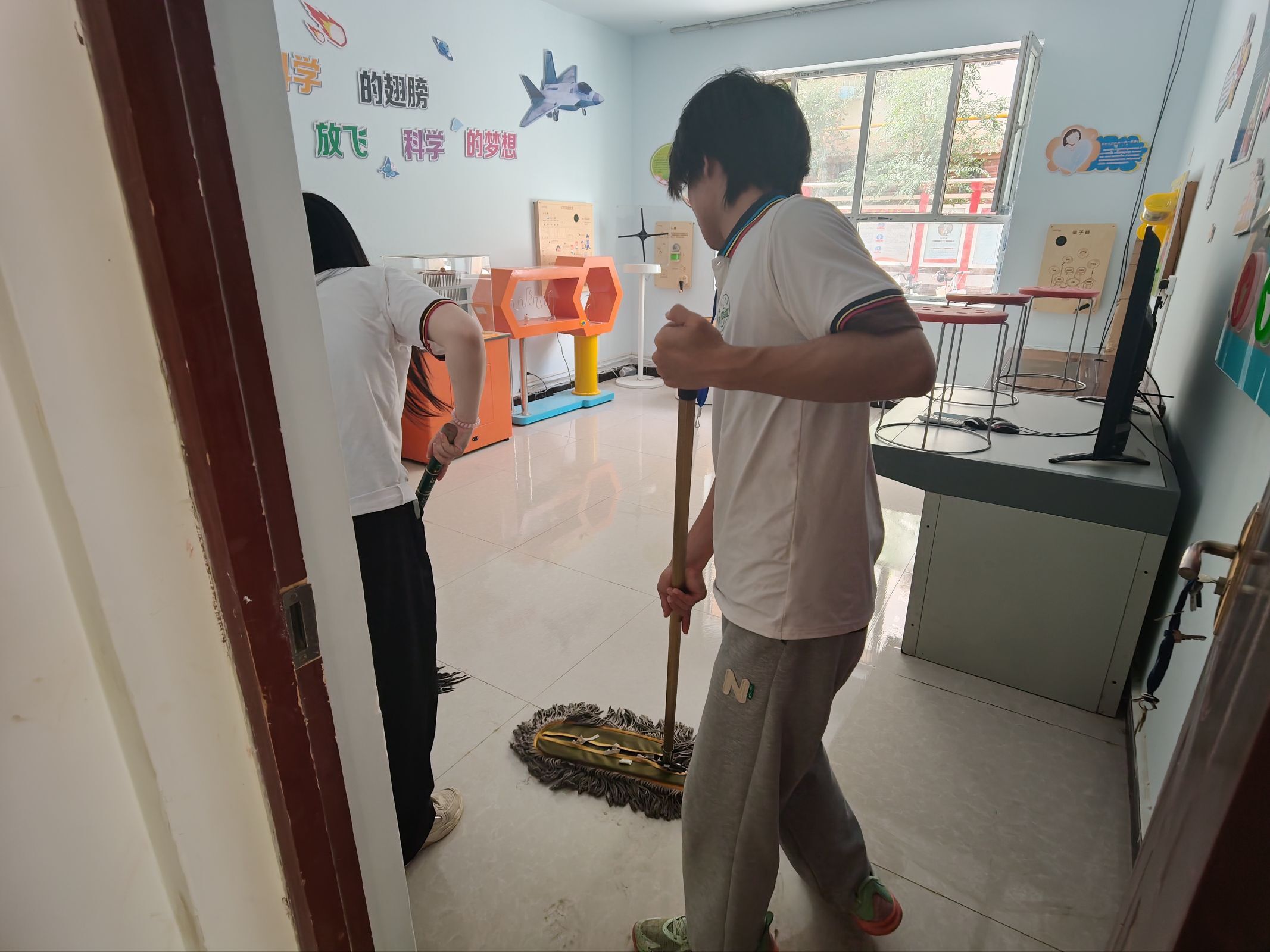 图3 实践队员们清扫社区文化活动场所.jpeg